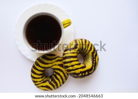 sweet dessert. round donut with chocolate icing and a cup of coffee