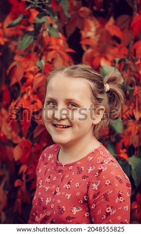 Portrait of young cute girl in pink dress smiling. Image with selective focus and toning