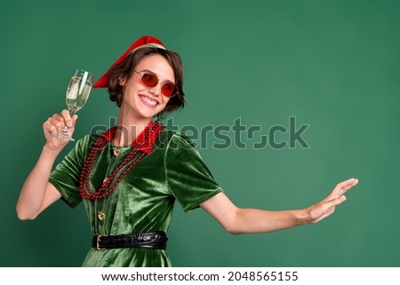 Photo of funny pretty young woman dressed elf costume glasses smiling drinking champagne dancing isolated green color background