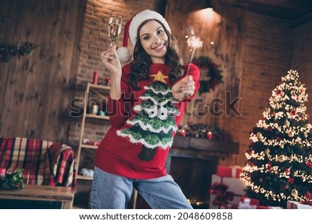 Photo of funny millennial brunette lady hold champagne sparklers wear holliday sweater hat at home alone