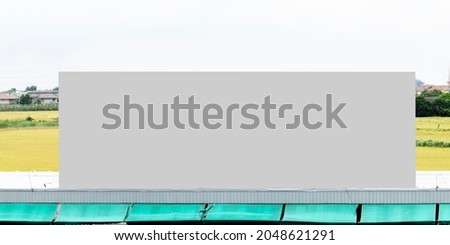 Outdoor billboard on roof and blue sky background with gray background mock up. clipping path