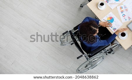 Top view shot of Asian unidentified unrecognizable female handicapped disabled businesswoman officer staff in formal business clothing sitting on wheelchair working meeting with other workers on desk. Royalty-Free Stock Photo #2048638862