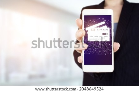 Credit card icon network connection on virtual screen background, business technology. Hand hold white smartphone with digital hologram credit card sign on light blurred background