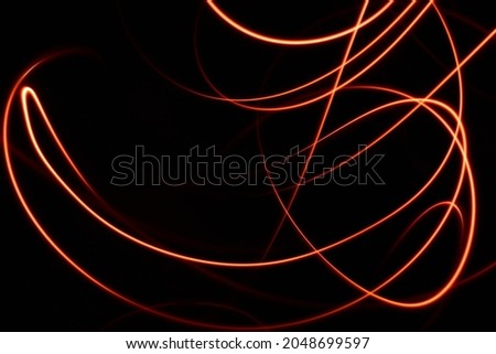Light painting done using two light sources.Light painting is isolated from the very dark black background.Red and white lights are used.Artistic creation.