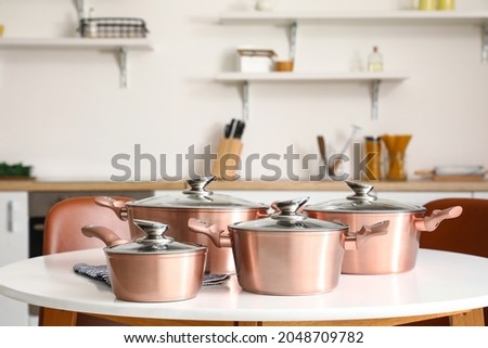 Set of copper cooking pots on table in kitchen Royalty-Free Stock Photo #2048709782
