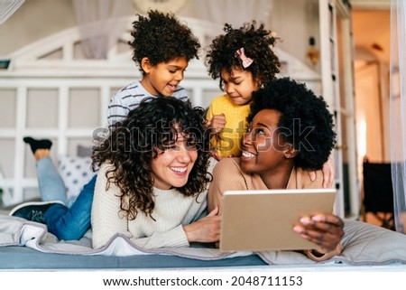 Family children gay parents concept. Happy multiethnic women couple having fun with kids at home Royalty-Free Stock Photo #2048711153