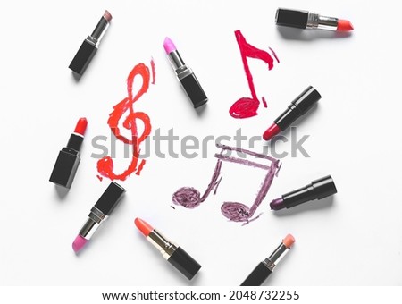 Drawn music notes and makeup cosmetics on white background