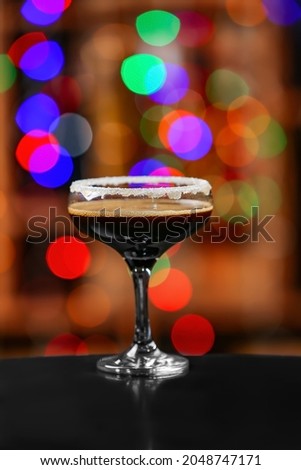 Glass of tasty espresso martini on blurred background