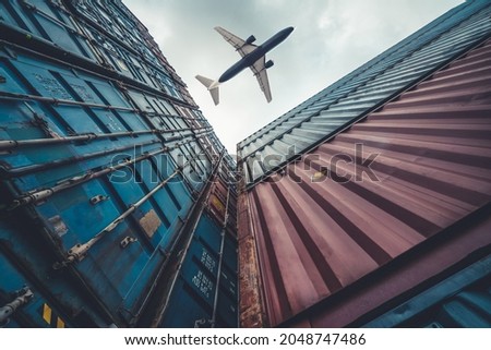 Freight airplane flying above overseas shipping container . Logistics supply chain management and international goods export concept . Royalty-Free Stock Photo #2048747486