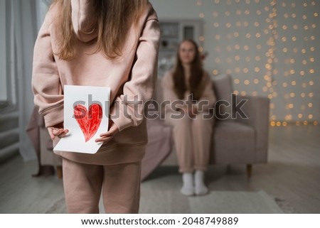 close-up of a child holding a card with a heart for mom