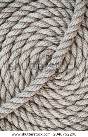Braided thick rope tied in a skein. Hemp rope for decoration and design. Background from fishing rope.