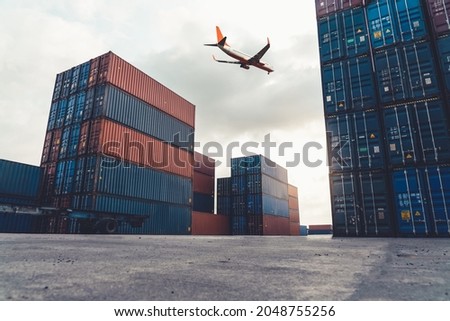 Freight airplane flying above overseas shipping container . Logistics supply chain management and international goods export concept . Royalty-Free Stock Photo #2048755256