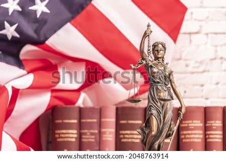 The statue of justice Themis or Iustitia, the blindfolded goddess of justice against a flag of the United States of America, as a legal concept. Royalty-Free Stock Photo #2048763914