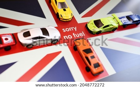 the inscription "sorry no fuel" on the background of the British flag and a queue of cars. The fuel crisis in Great Britain. Royalty-Free Stock Photo #2048772272