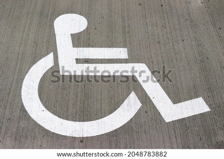 Handicap symbol on asphalt road. Lane reserved for wheelchairs