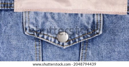 Blue denim jacket pocket close-up. 