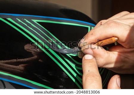 the artist creating the pinstriping image with a special brush