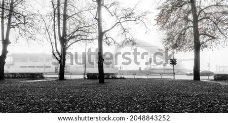 Foggy morning in public park near a rail station of small European town, photo done with black and white post production tools
