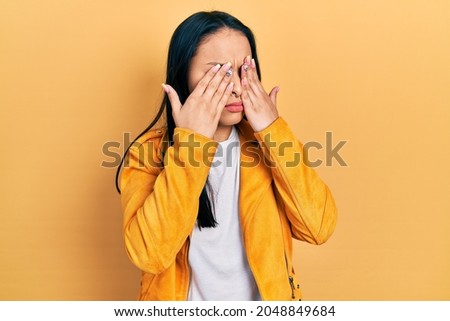 Beautiful hispanic woman with nose piercing wearing yellow leather jacket rubbing eyes for fatigue and headache, sleepy and tired expression. vision problem 