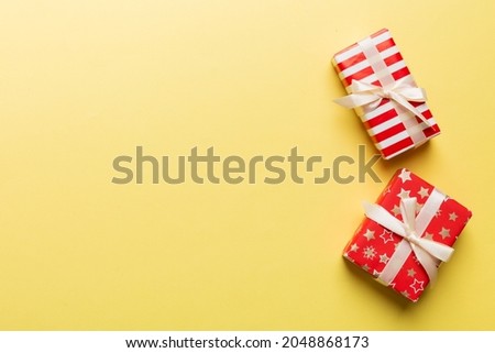 Holiday flat lay with gift boxes wrapped in colorful paper and tied decorated with confetti on colored background. Christmas, Birthday, Valentine and sale concept, top view.
