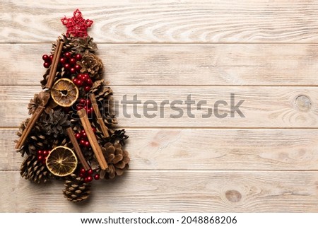 Christmas tree made from natural cones on colored background, view from above. New Year minimal concept with copy space.