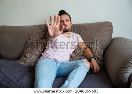 Make-up trans guy waving his hand at the stop of homophobia