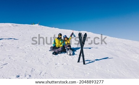 couple skier and snowboarder at the top of the mountains at sunny day winter vacation