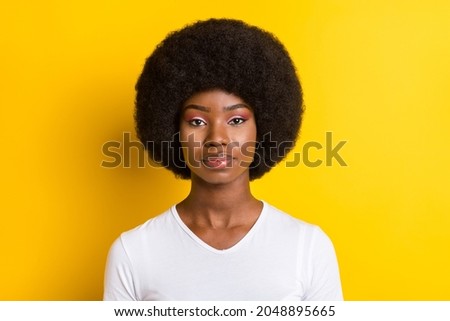 Photo of serious young dark skin woman calm peaceful face volume hairstyle isolated on yellow color background
