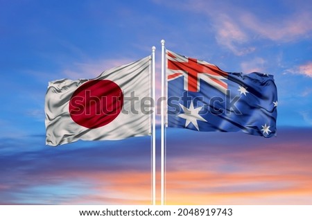 Australia and Japan flag waving in the wind against white cloudy blue sky together. Diplomacy concept, international relations.