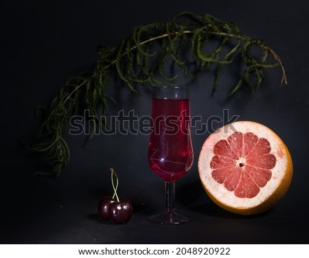 photo of a glass of red wine on a dark background with berries and fruits. with space to copy. a stylish composition in advertising. for the presentation of alcoholic beverages. impressive.