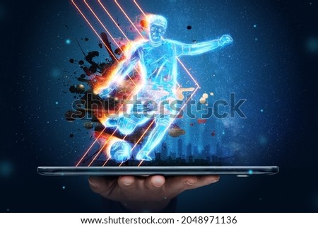 A hologram of a football player running out of a smartphone screen. The concept of sports betting, football, gambling, online broadcast of football