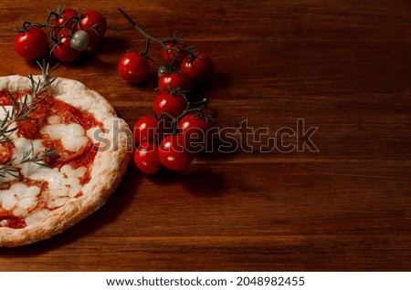Italian pizza on a dark wooden cutting board