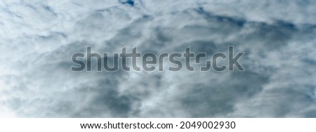 Panorama of cloudy gray sky. Dark sky with white clouds. Background for design. Space for text.