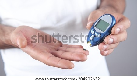 Man measuring glucose level at home. Royalty-Free Stock Photo #2049026321