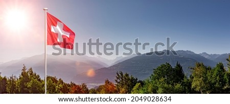 Swiss flag in Valais in front of Rhone valley Royalty-Free Stock Photo #2049028634