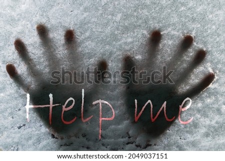 Human hands on the frozen glass with snow on the car