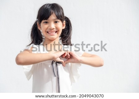 Little girl hands making a heart shape on white background