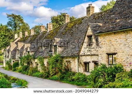 Traditional row of stone cottage houses on Arlington Row in Bibury village, Gloucestershire, The Cotswolds, England UK Royalty-Free Stock Photo #2049044279