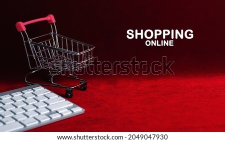 Shopping cart with text online shopping on dark red background.                   Shopping and Supermarket concept.