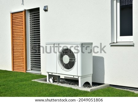 Air-Air Heat Pump for Heating and hot Water in Front of an new built Residential Building Royalty-Free Stock Photo #2049051806