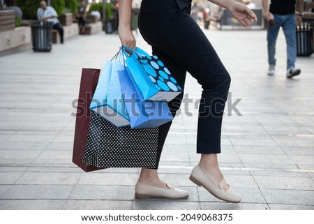 woman hand colorful shopping bags in the street