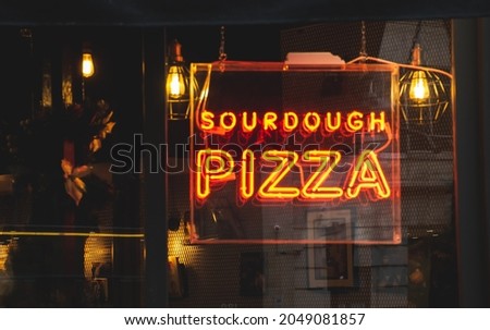 Image of sourdough pizza neon text in the window.