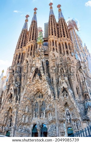 Facade of unfinished sacred family "La Sagrada Familia" , cathedral designed by Gaudi, being built since 19 March 1882 with people donations. The text "Sanctus" in the facade means saint Royalty-Free Stock Photo #2049085739