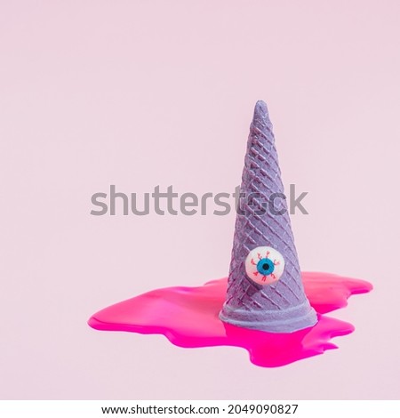 Icecream cone with bloody eyeball. Spooky idea with neon pink oil paint texture on pastel background. Halloween concept.