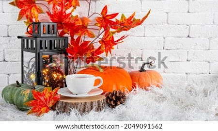  A cup of tea with lemon, autumn leaves and pumpkin. The concept of a cozy autumn at home. Banner for website with free space for text. High quality photo