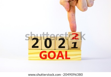 Planning 2022 goal new year symbol. Businessman turns a wooden cube and changes words 'Goal 2021' to 'Goal 2022'. Beautiful white background, copy space. Business, 2022 goal new year concept.