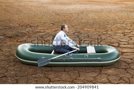 Dumb funny Business man stop on crack soil hot land desert boat businessman rock look bright future symbol crisis stagnation losses braking difficulties environmental disaster water scarcity drought Royalty-Free Stock Photo #204909841