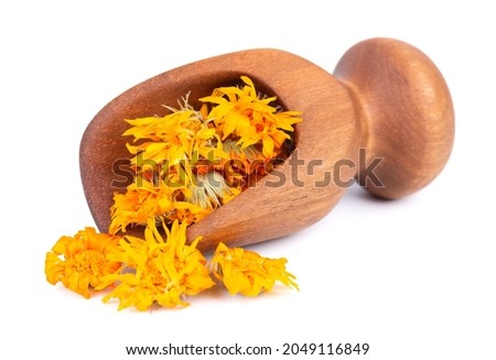 Dried calendula flowers in wooden scoop, isolated on white background. Petals of Calendula officinalis. Medicinal herbs.
