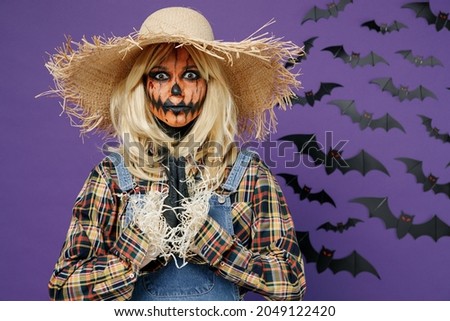 Young woman with Halloween makeup mask wear straw hat scarecrow costume fold hands in prayer gesture beg isolated on plain dark purple background studio portrait. Celebration holiday party concept.