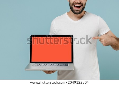 Cropped close up young man in white blank print design t-shirt hold use work point index finger on laptop pc computer blank screen workspace area isolated on plain pastel light blue background studio.